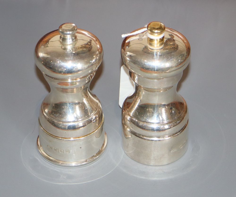 A pair of modern silver pepper mills, David R. Mills, London, 1995 & 1998, 11.1cm, one with gilded finial.